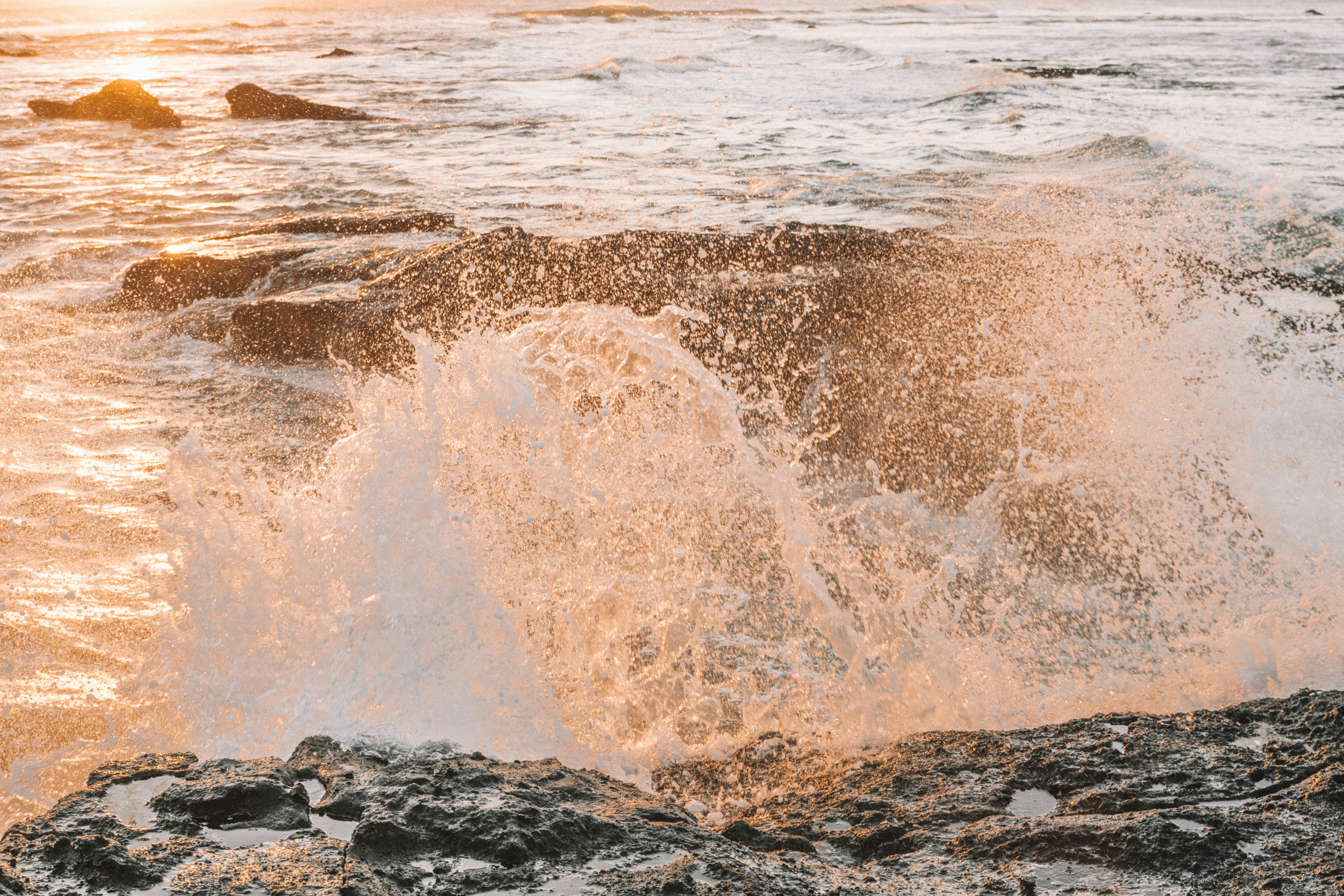 ocean waves crashing on rocky shore during daytime